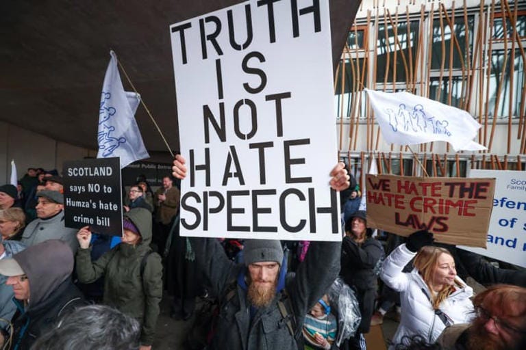 Protester holds up poster reading 'truth is not hate speech'