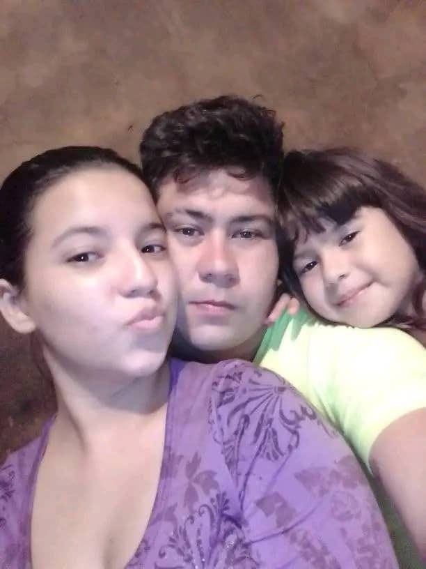 A mother father and daughter pose with their heads close together for a selfie A mother father and daughter pose with their heads close together for a selfie
