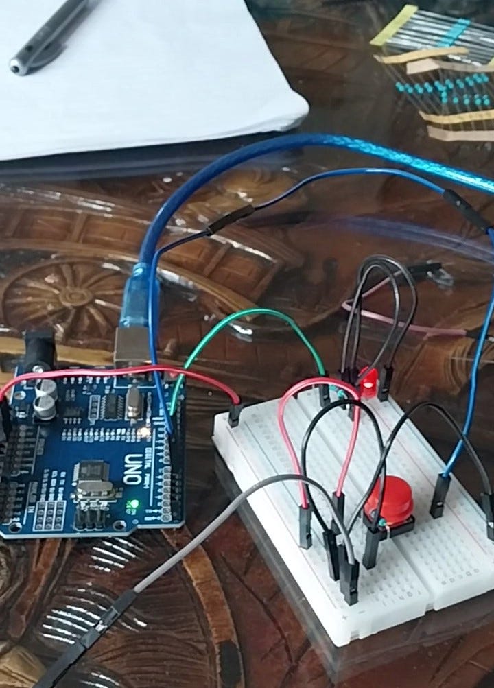 A simple circuit connected to a LED, a button, and an arduino board