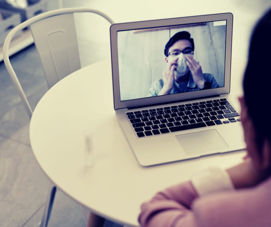 Man sitting alone wearing mask during a video call