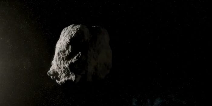 A large grey asteroid floating in space with one side of it's surface illuminated.