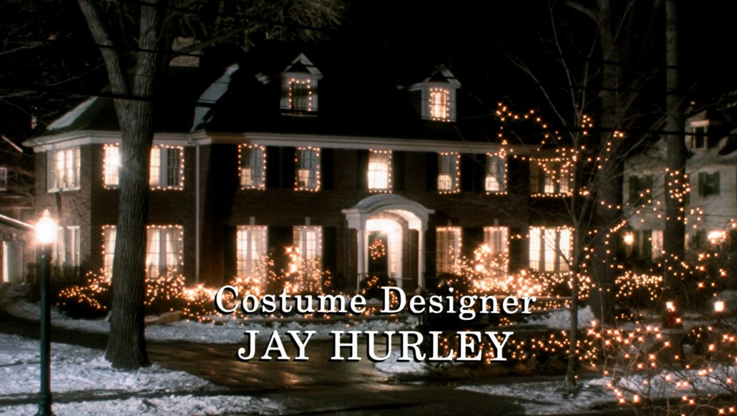 A screenshot from the "Home Alone" film; the house is covered in white Christmas lights. They are lining each window, the bushes, and a couple of smaller trees out front.