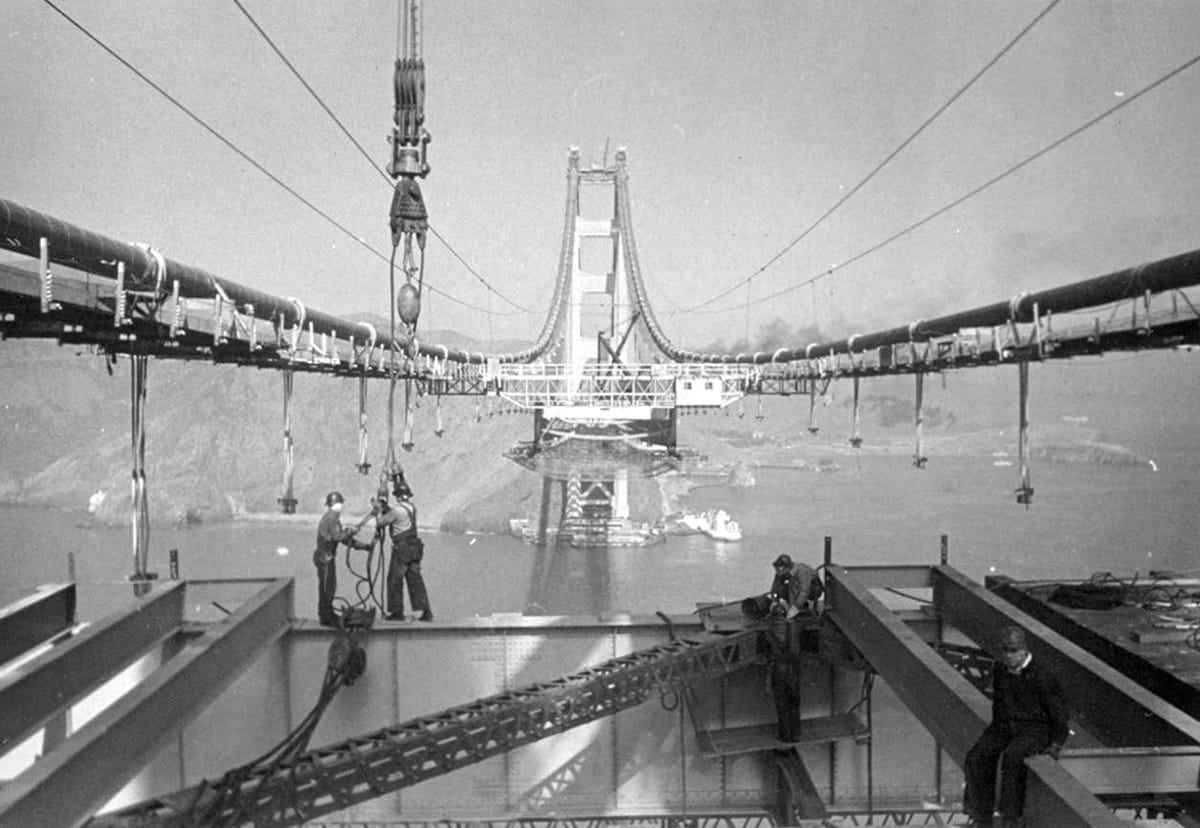 men work on the not-finished bridge in a black and white image
