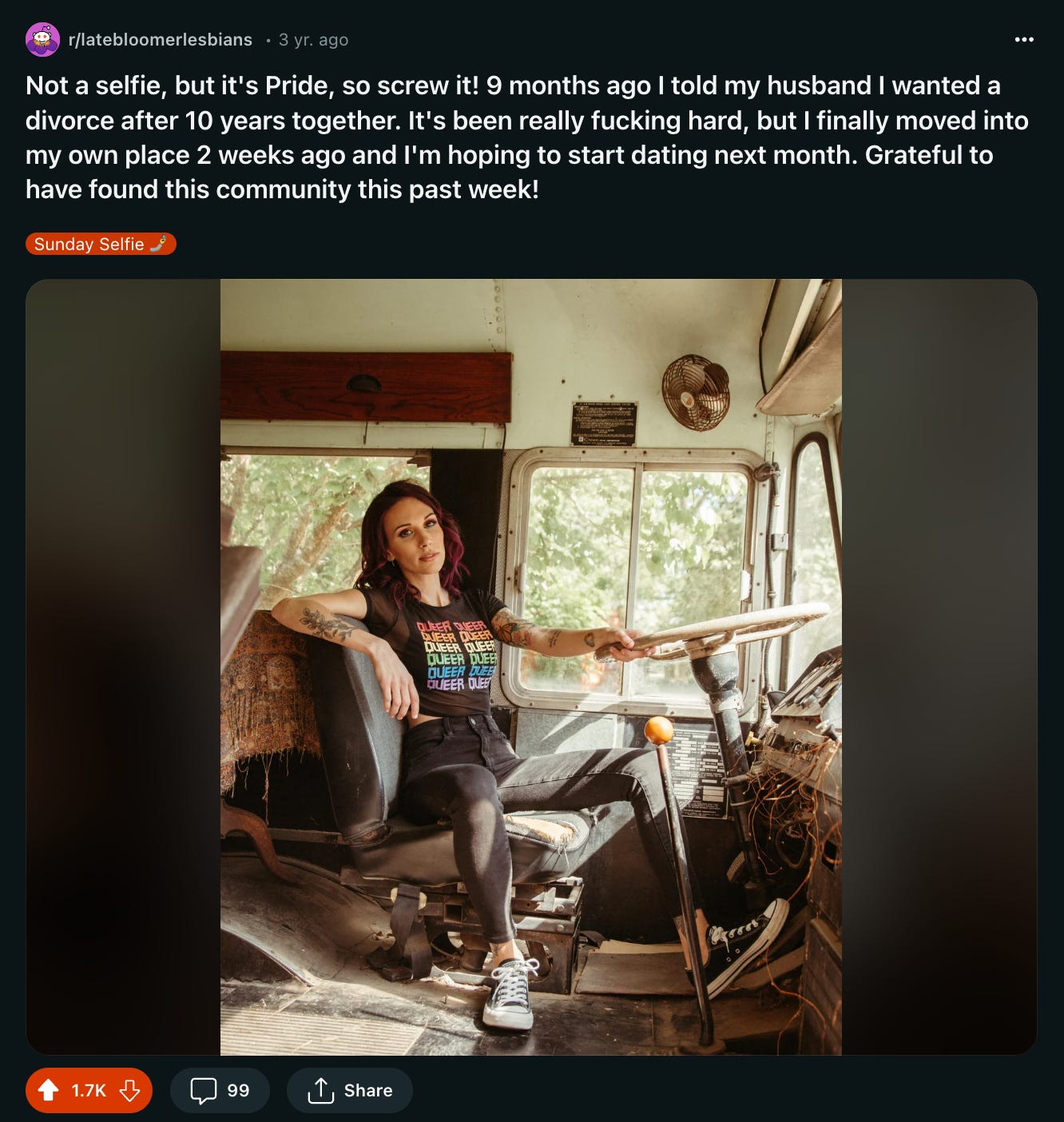 A photo of Shohreh in the driver's seat on a bus holding onto the wall with one hand with her other arm draped over the seat while wearing a shirt that says "Queer" on it repeatedly in rainbow colors with a caption about it being Pride month.