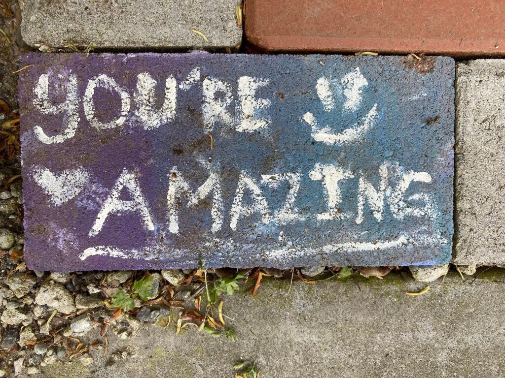 Brick in a sidewalk with the words "You're amazing"