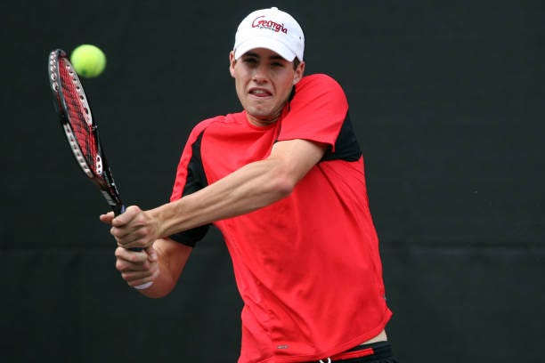 John Isner of the University of Georgia returns serve against Kevin Anderson and Ryan Rowe of the University of Illinois during the Division I Men's...