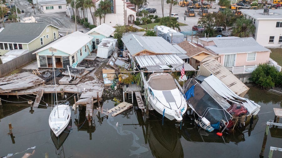 Aerial drone view of damaged homes and a vehicle into the canal after storm surge from Hurricane Helene on Saturday, Sept. 28, 2024 in Madeira Beach. 