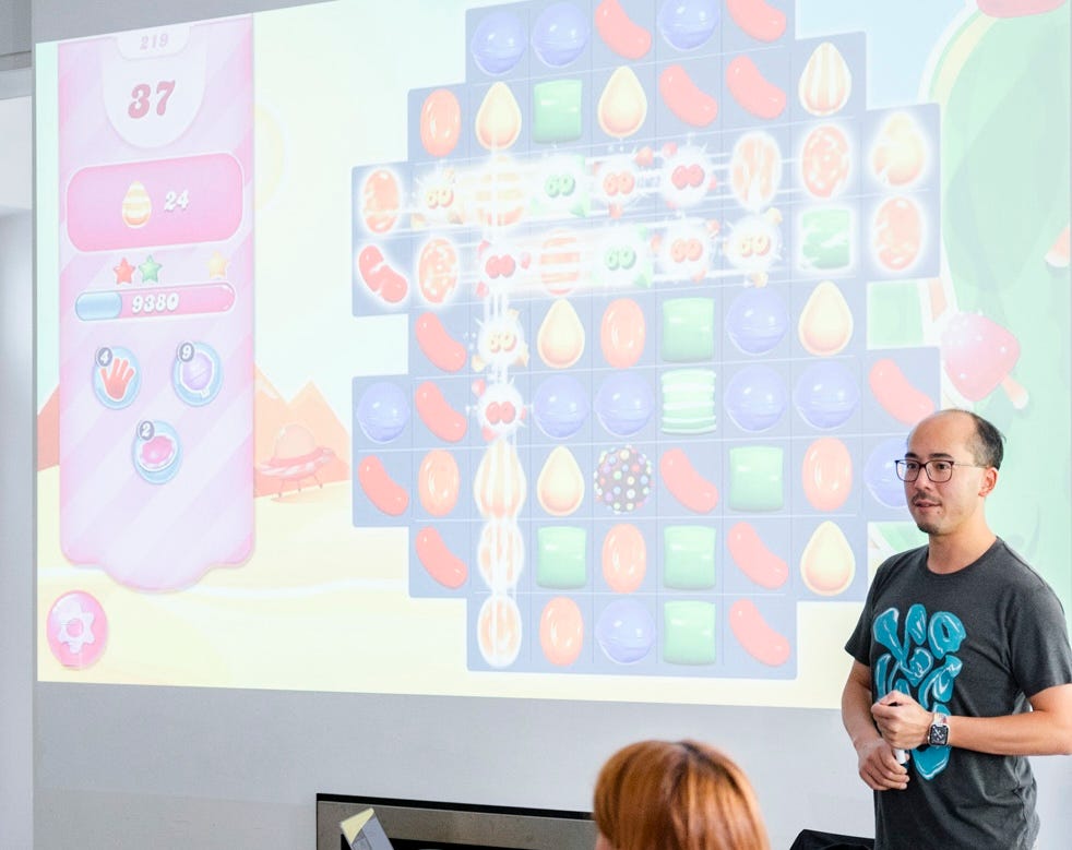 Adrian standing in front of a projection of Candy Crush