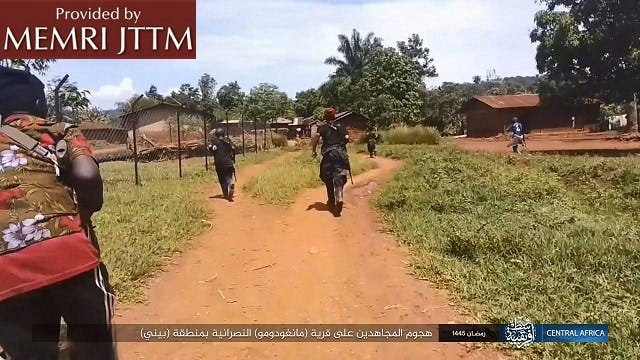 A group of people walking on a dirt roadDescription automatically generated