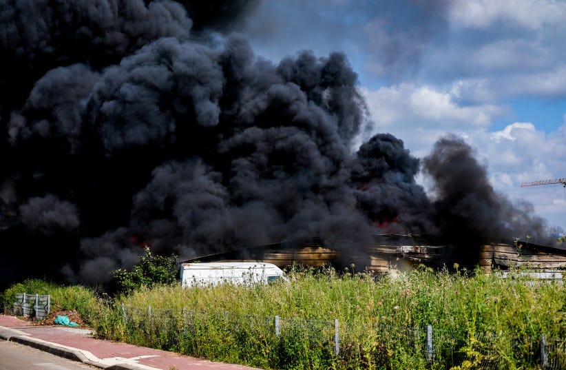  Firefighters try to extinguish a fire caused after a rocket fired from Lebanon hit near the Israeli town of Shlomi, April 6, 2023 (photo credit: FLASH90/FADI AMUN)