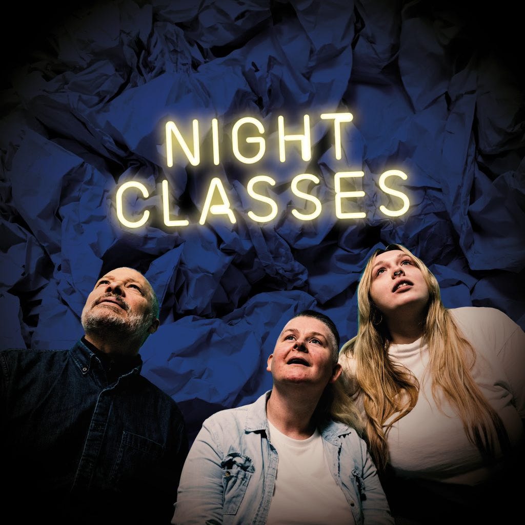 Three people looking up. Above their heads it says NIGHT CLASSES in yellow neon