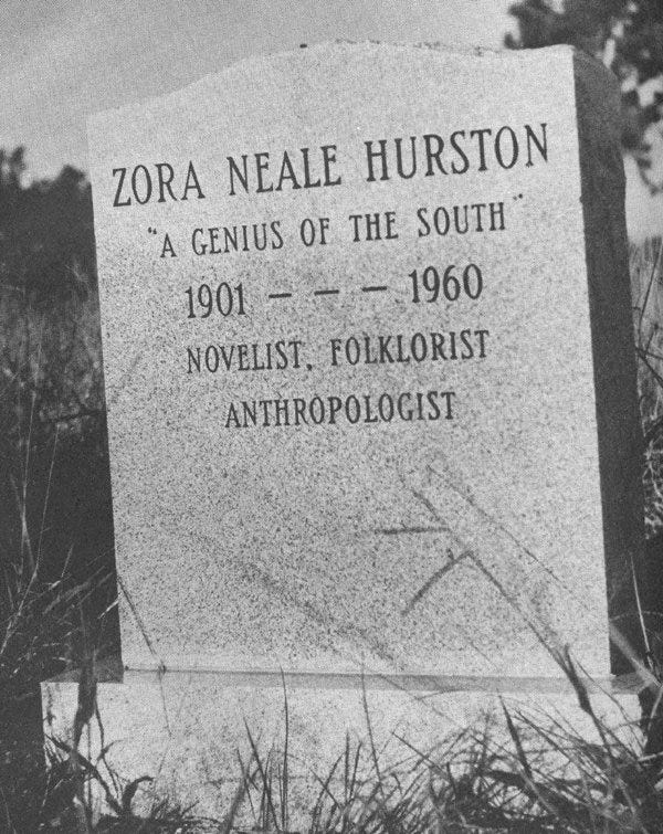 a black and white photo of a headstone that reads Zora Neale Hurston "A Genius of the South" 1901 to 1960 Novelist, folklorist, anthropologist