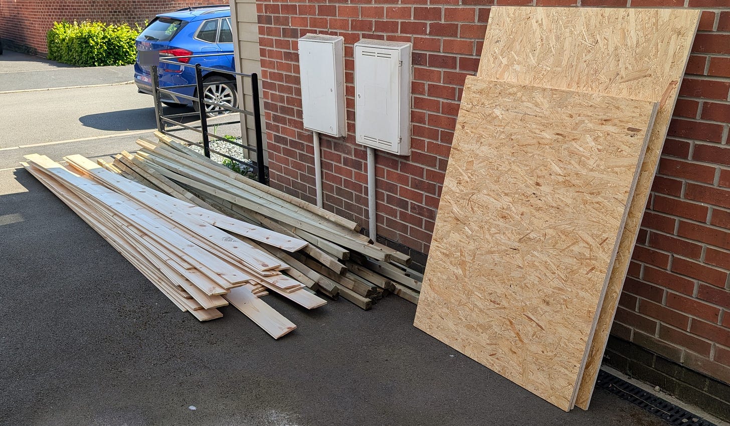 An image showing my driveway with all of the wood as it was delivered. 