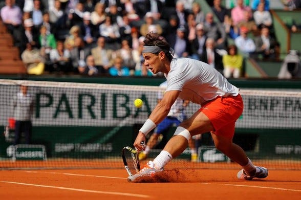 rafael nadal digging in clay court for fabio fognini bare tennis back action 2015