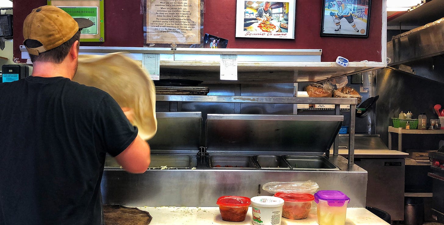 Josh Sickels has some iconic people hung above his pizza making station.