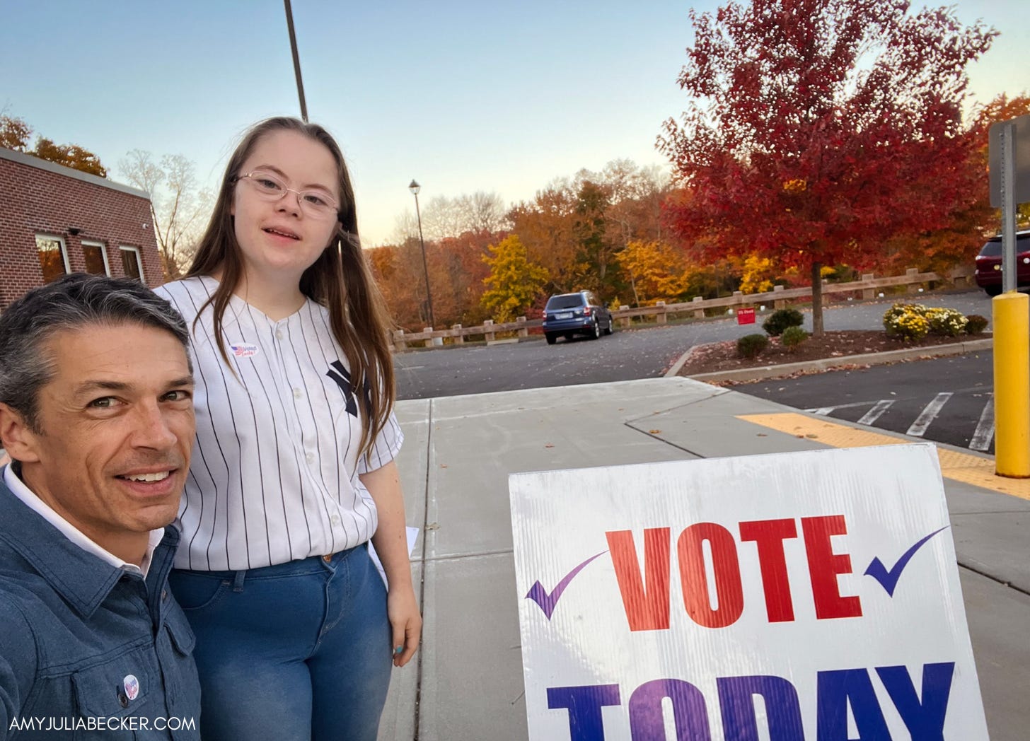 Peter and Penny take a selfie outside by a Vote Today sign