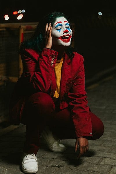 File:Shallow Focus Photo of Person in Red Coat With Clown Face Paint.jpg