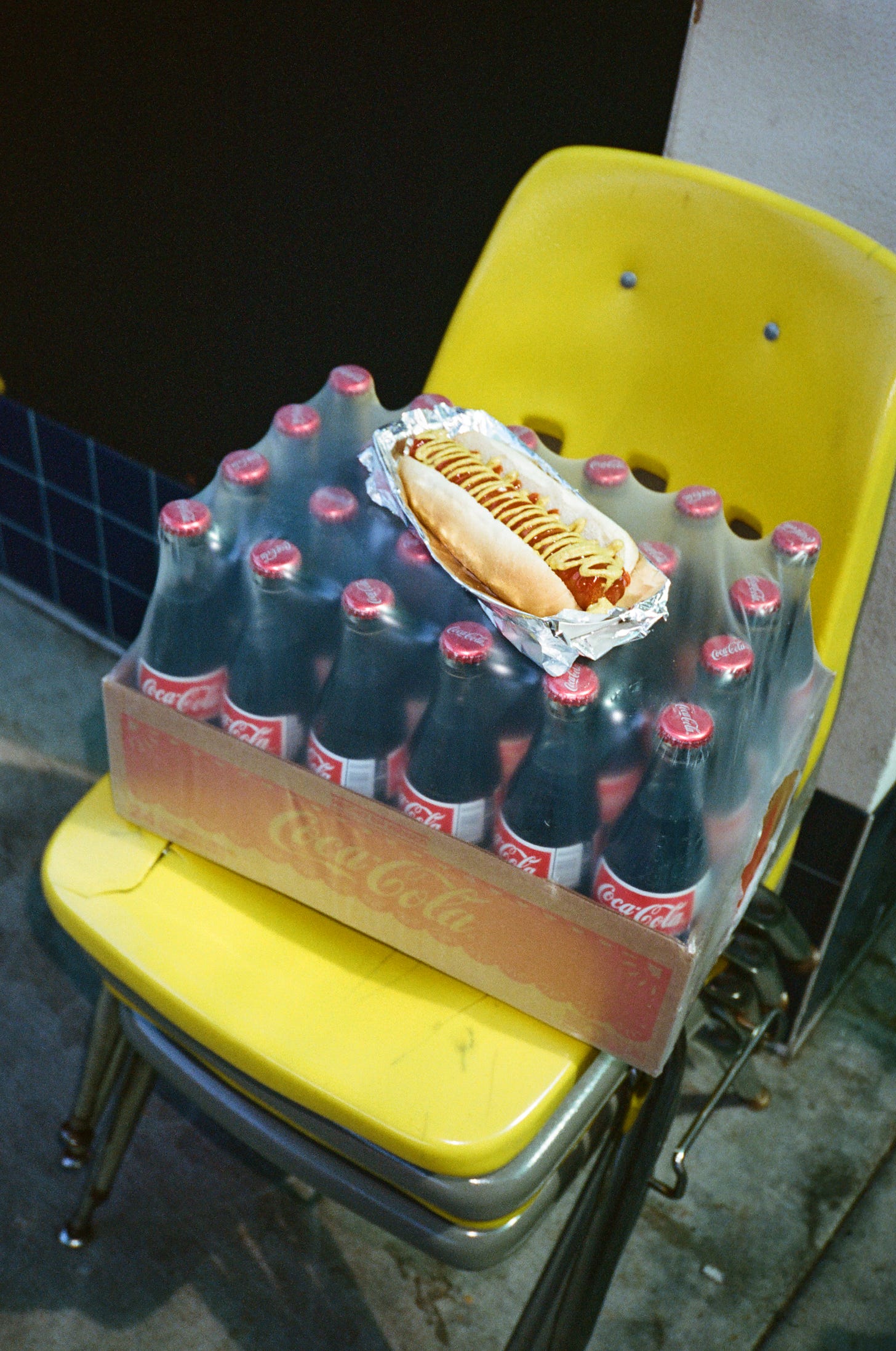 A Walt's hot dog sits on a case of Coca-Cola