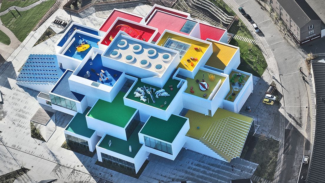 A multi-colored building with a playground

Description automatically generated