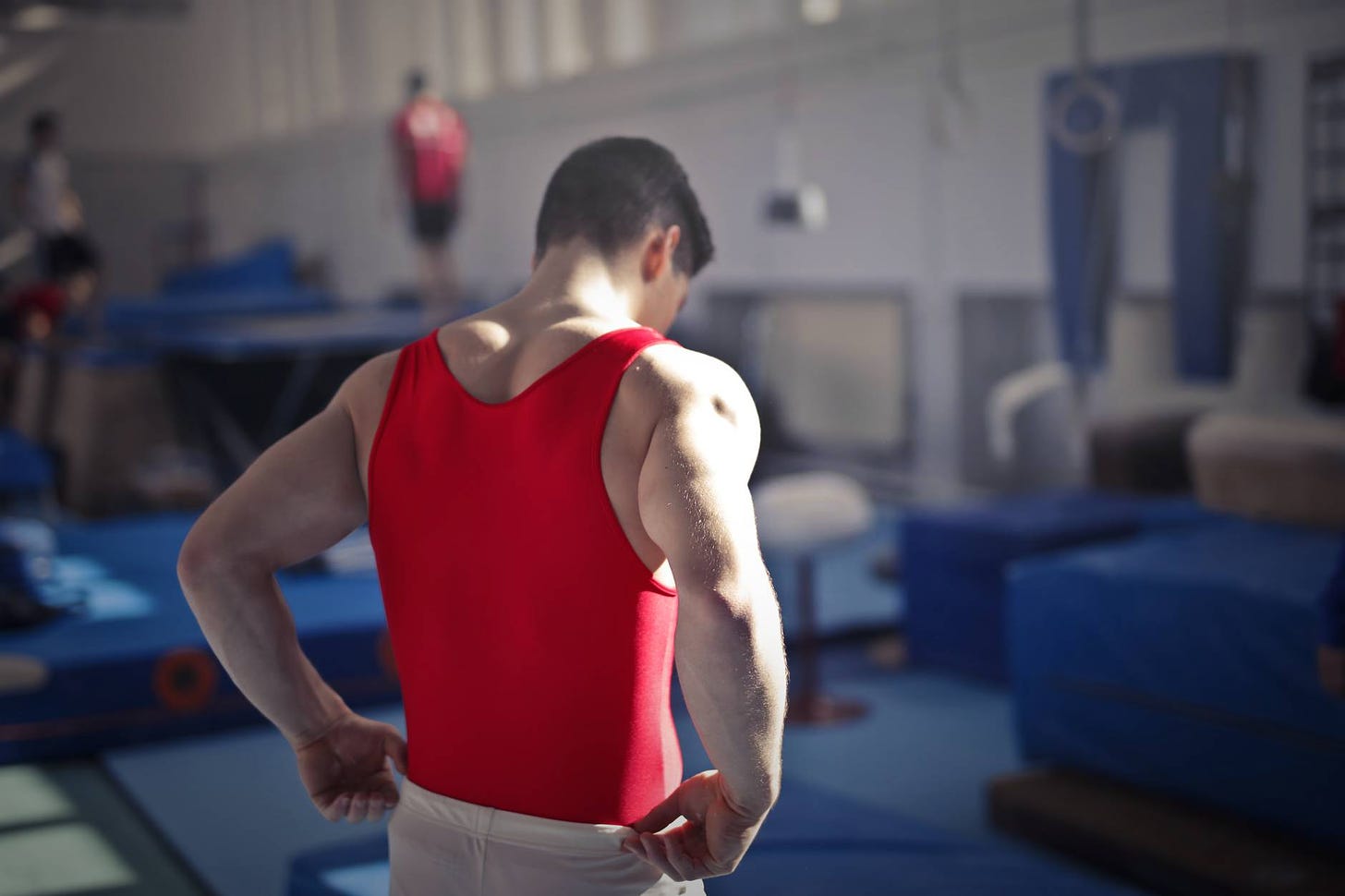 male gymnast in spacious sports hall motivated