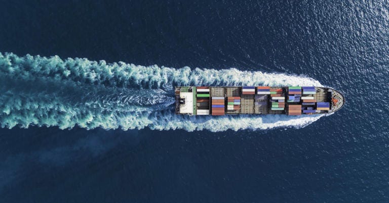 Aerial top view container ship full speed with beautiful wave pattern for logistics, import export, shipping or transportation.
