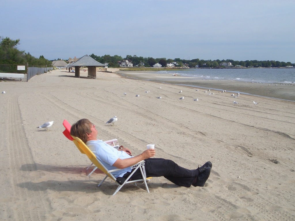 Photo by Author — I’m far too busy…. author relaxing on a desckchair on an empty beach