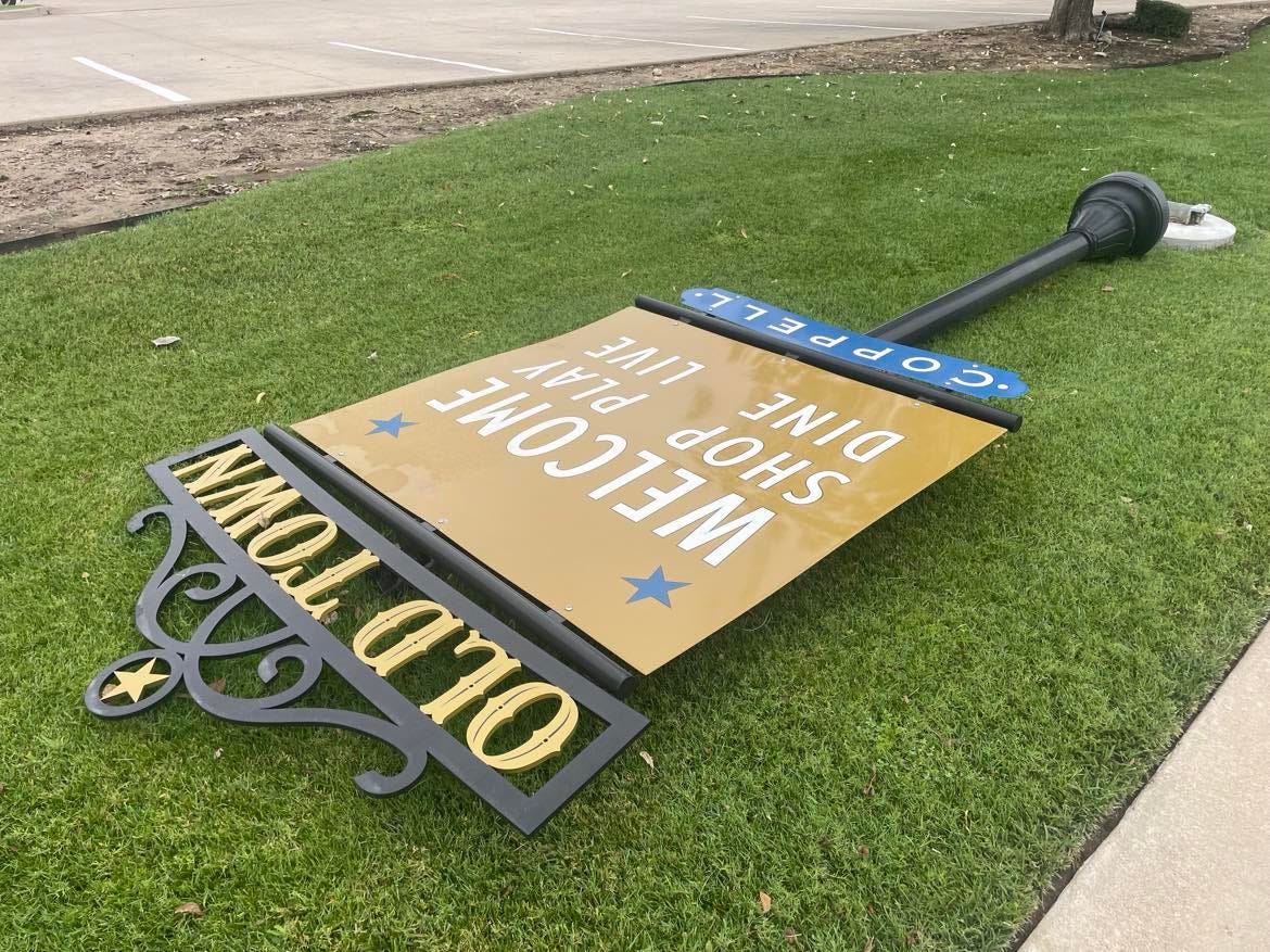 An Old Town welcome sign laying on the grass