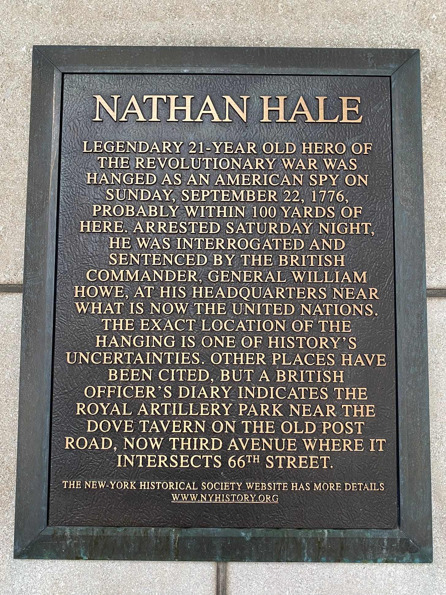 A plaque that reads "NATHAN HALE. Legendary 21-year old hero of the Revolutionary War was hanged as an American spy on Sunday, September 22nd 1776, probably within 100 years of here. Arrested Saturday night, he was interrogated and sentenced by the British commander, General William Howe, at his headquarters near what is now the United Nations. The exact location of the hanging is one of history's uncertainties. Other places have been cited, but a British officer's diary indicates the Royal Artillery Park near the Dove Tavern on the Old Post Road, now Third Avenue where it intersects 66th Street. The New-York Historical Society website has more details www.nyhistory.org"