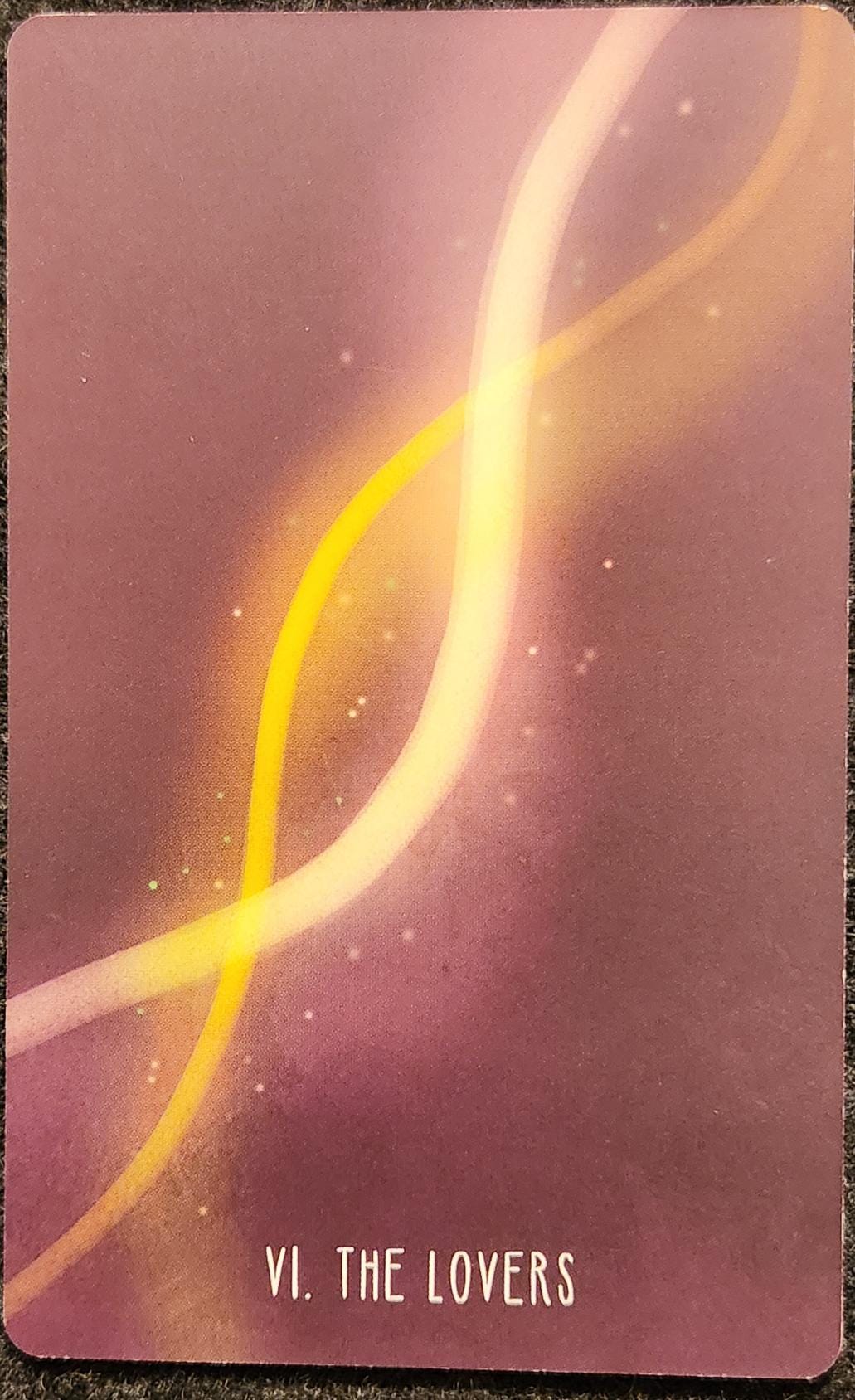 A tarot card labelled VI The Lovers. It shows two strands of energy, spiralled around each other like a double helix. There is an aura of light around the intertwined strands. The background is a dusty pink.