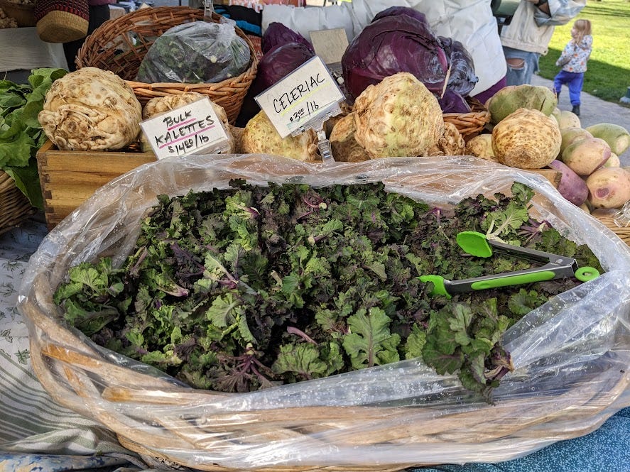 an overflowing bag of kalettes at the farmers market