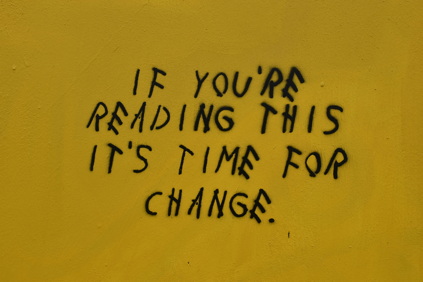 black writing on a yellow wall