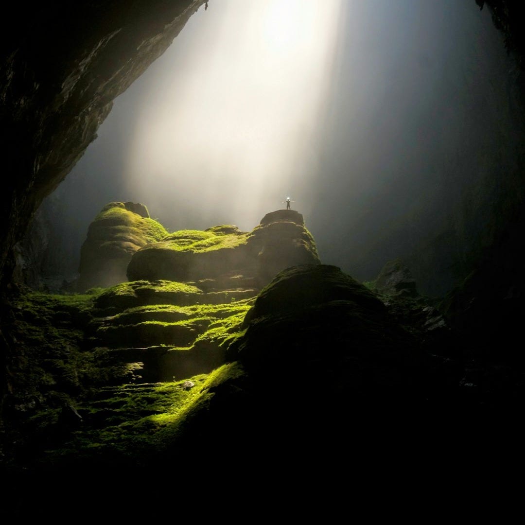 person on top of rock formation inside cave person on top of rock formation inside cave