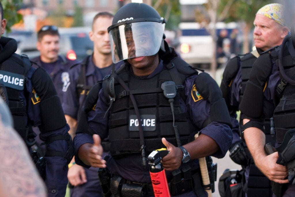 "Cop - Pepper Spray / Riot Gear" by Tony Webster under CC BY 2.0