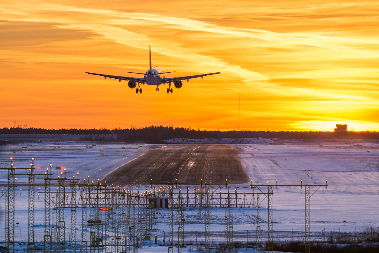 Plane lands in the sunset on a snowy runway