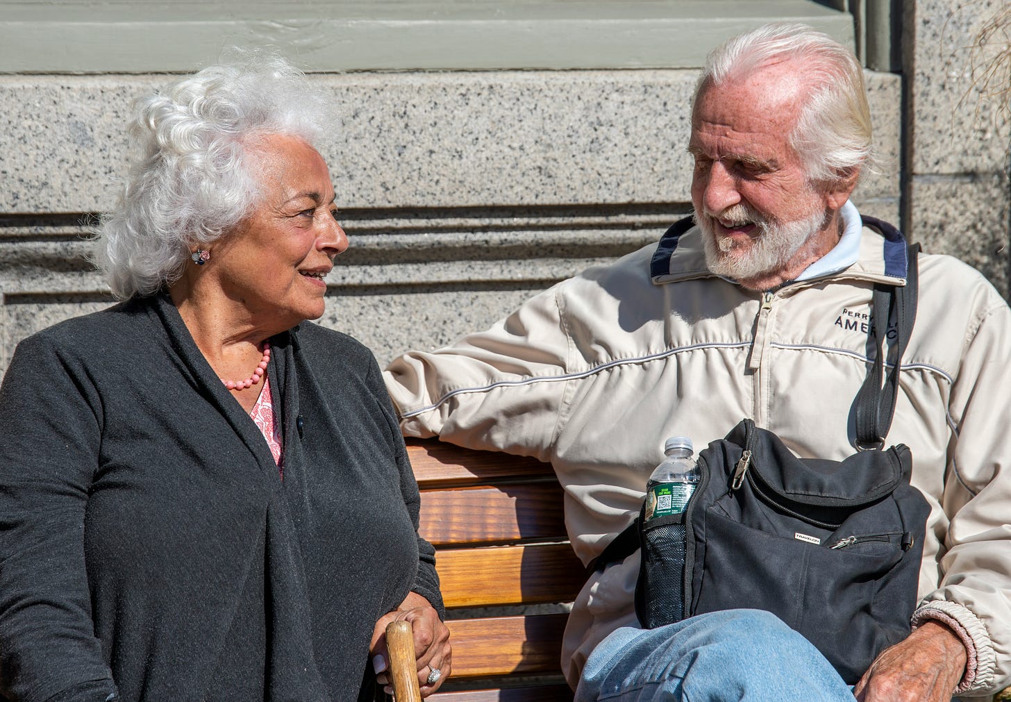 Happy elderly couple enjoying a Sunday morning on city bench in Rockport, Massachusetts
