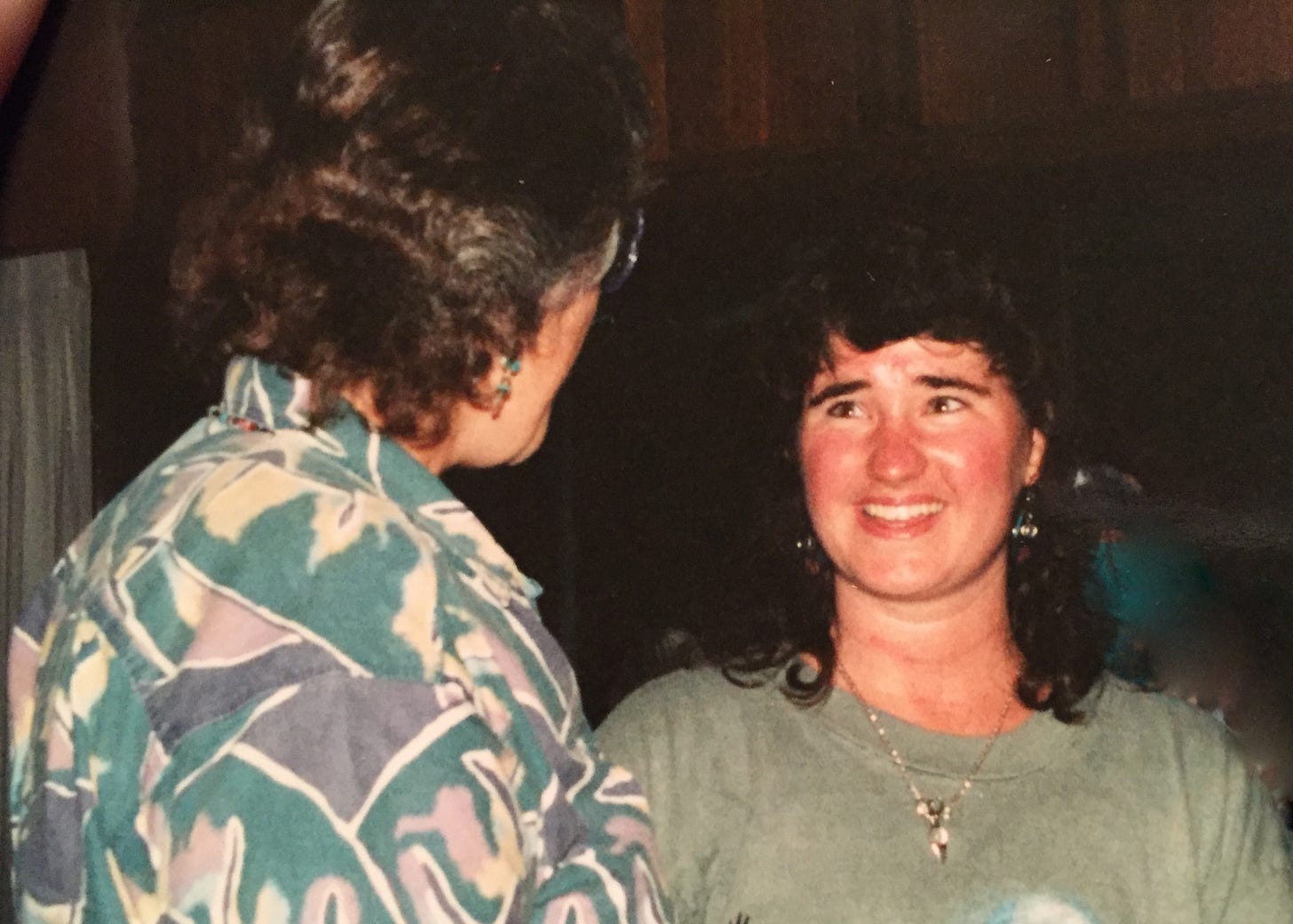 A young woman with shoulder length brown hair talking with an older womanhair sm