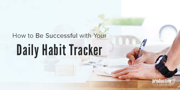 Someone's hands are placed on a wood desk, and they are writing on paper. Text Overlay: How to Be Successful with Your Daily Habit Tracker