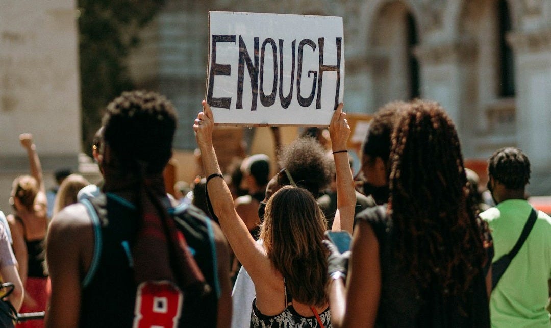 people holding a signage during daytime