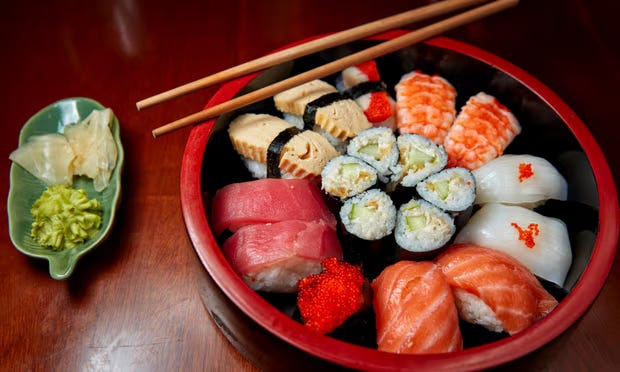 Uma combinado de sushi com dois hashis em cima