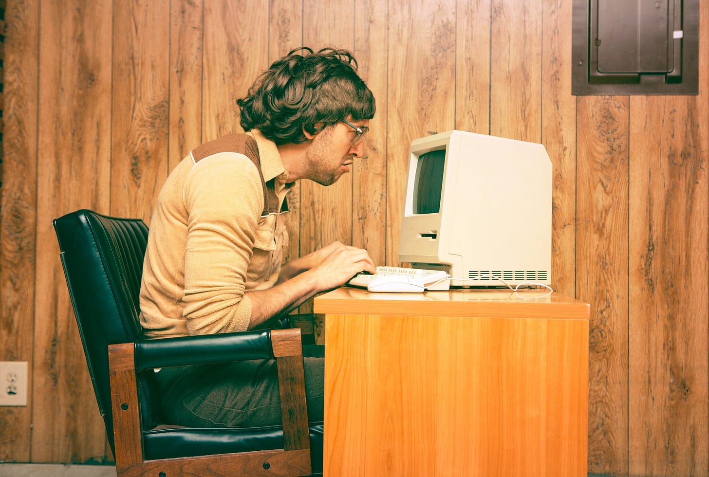 Funny Nerdy Man Looking Intensely at Vintage Computer