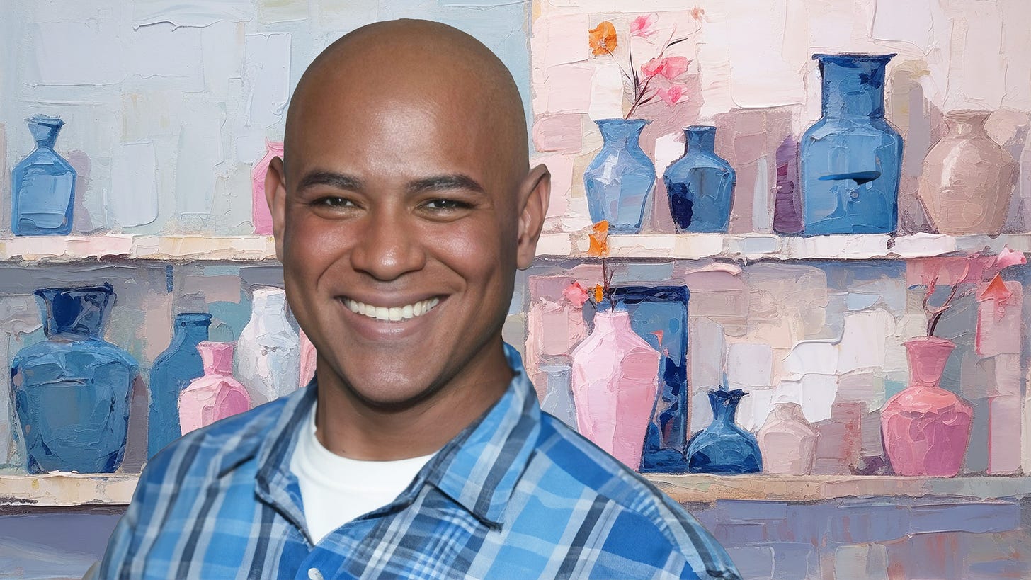 headshot of a smiling black man with a shaved head, in front of an abstract painting of blue and pink ceramics