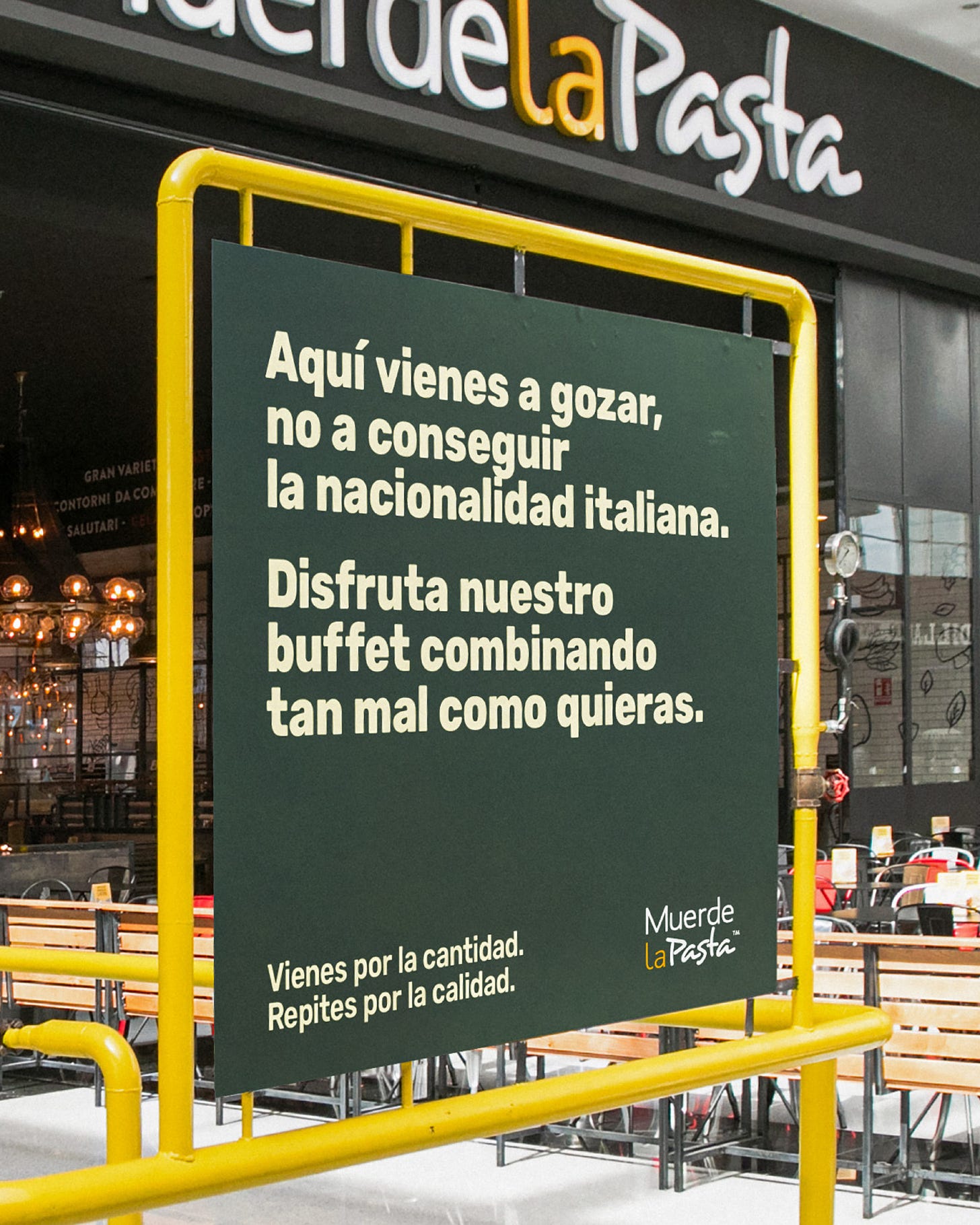 Un cartello all'ingresso di un negozio Muerde la Pasta che dice "Aquí vienes a gozar, no a conseguir la nacionalidad italiana. Disfruta nuestro buffet combinando tan mal como quieras." La traduzione è sotto l'immagine.