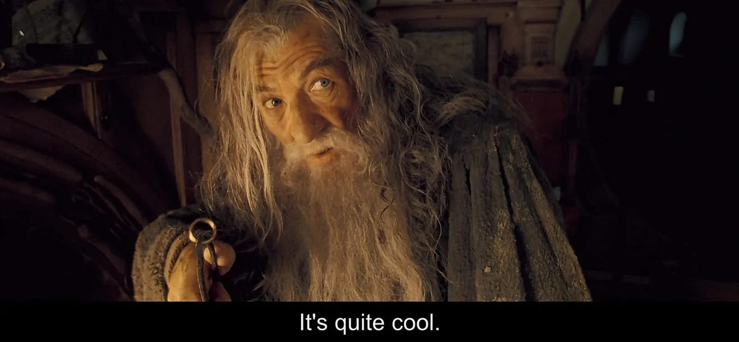 Gandalf holds the ring to Bilbo with a set of tongs—the text below reads "It's quite cool."