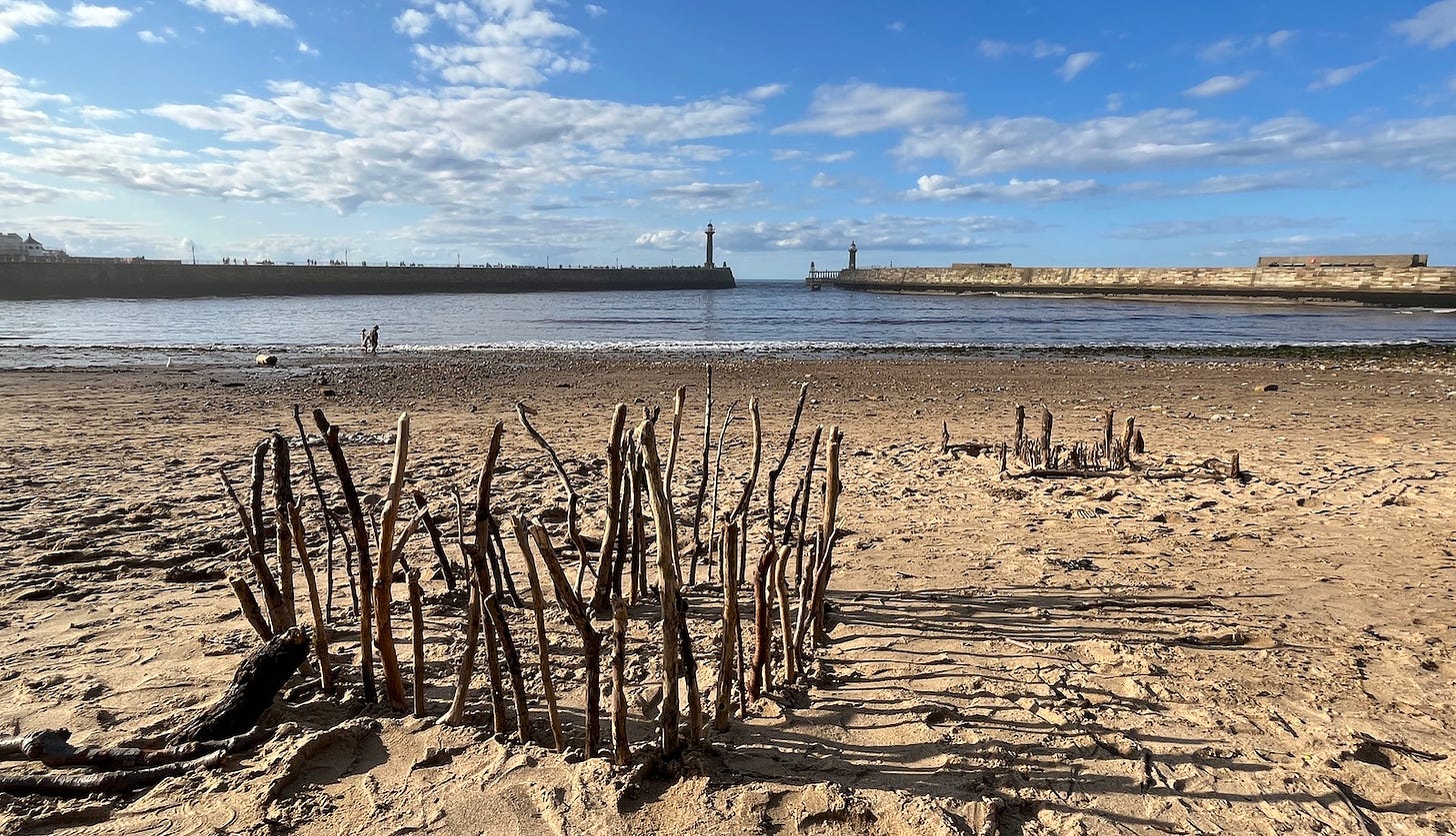 Driftwod castles on the sands of Whitby Bay, August 2023
