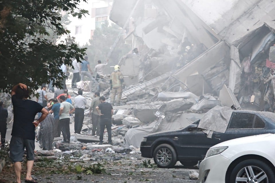 Aftermath of airstrikes in Tehran, showing damaged buildings and people surveying the scene.