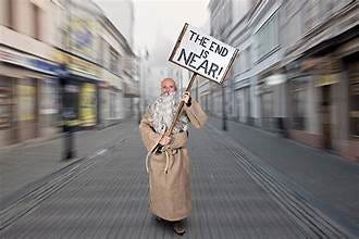 A person in a robe holding a sign

Description automatically generated