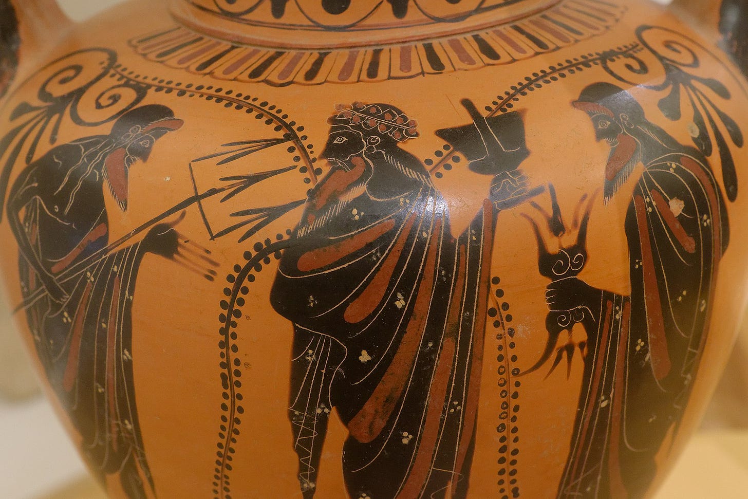 color photograph of a black figure vase showing From left to right: Poseidon, Dionysos, Zeus. Black figured neck-amphora, 540 BC. National Museum of Denmark, Copenhagen