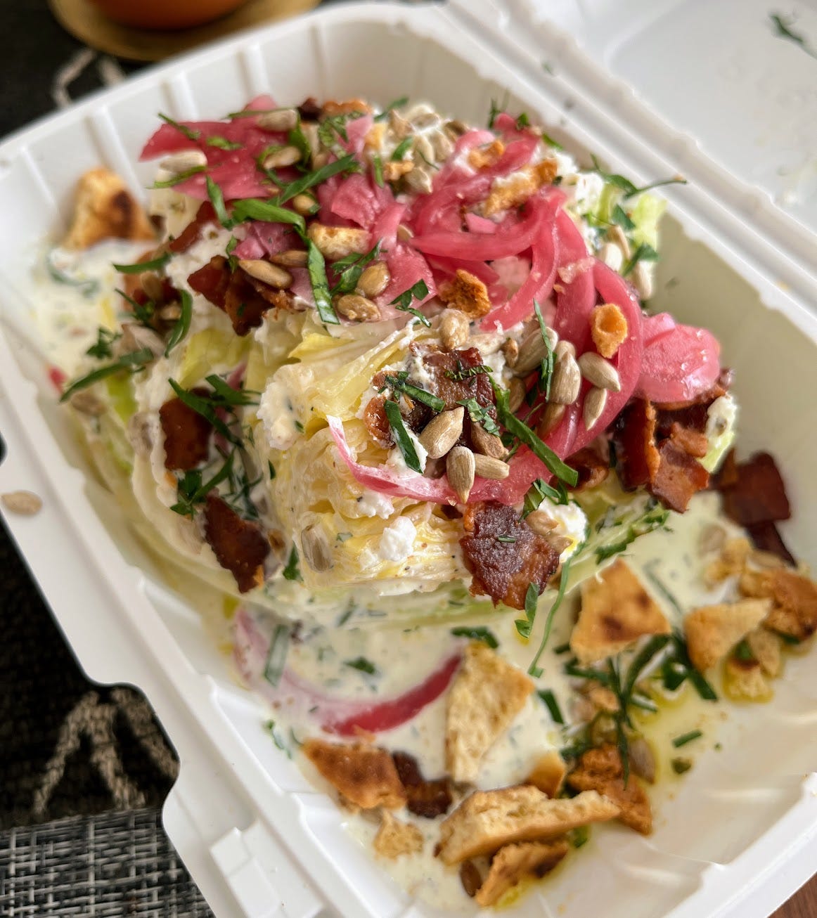 A wedge salad in a take out box