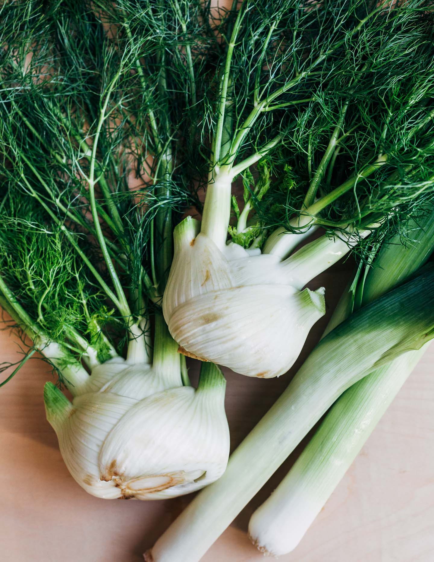 Fennel and leeks on a cutting board.