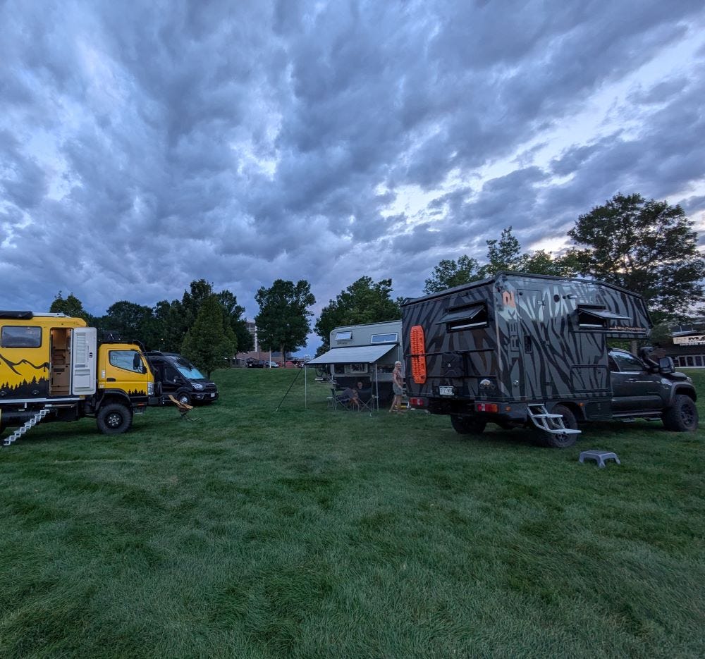 the same group of campers, but under dark clouds and fading light